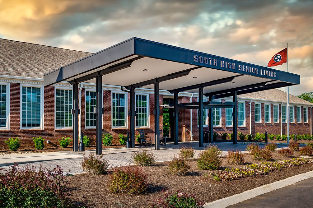 A modern school building with a covered entrance and landscaped surroundings.