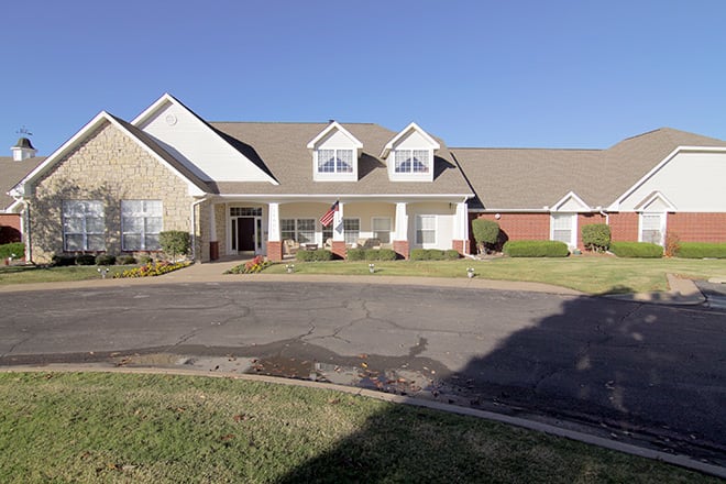 A suburban residential house with a large front lawn and driveway.