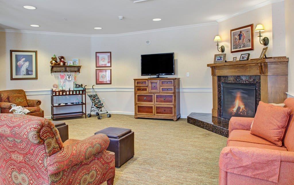 A cozy living room featuring a fireplace, television, and comfortable furniture.