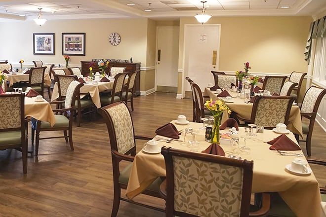 An elegant dining room with neatly arranged tables and chairs in a calm, well-lit setting.