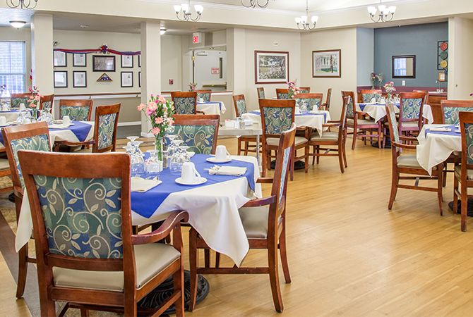 A well-arranged dining room with elegantly set tables and comfortable chairs.