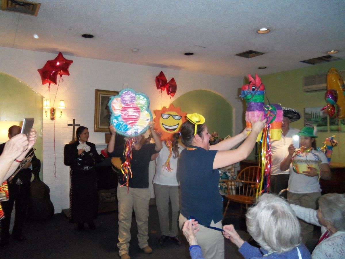 A group of people celebrating indoors with colorful balloons.