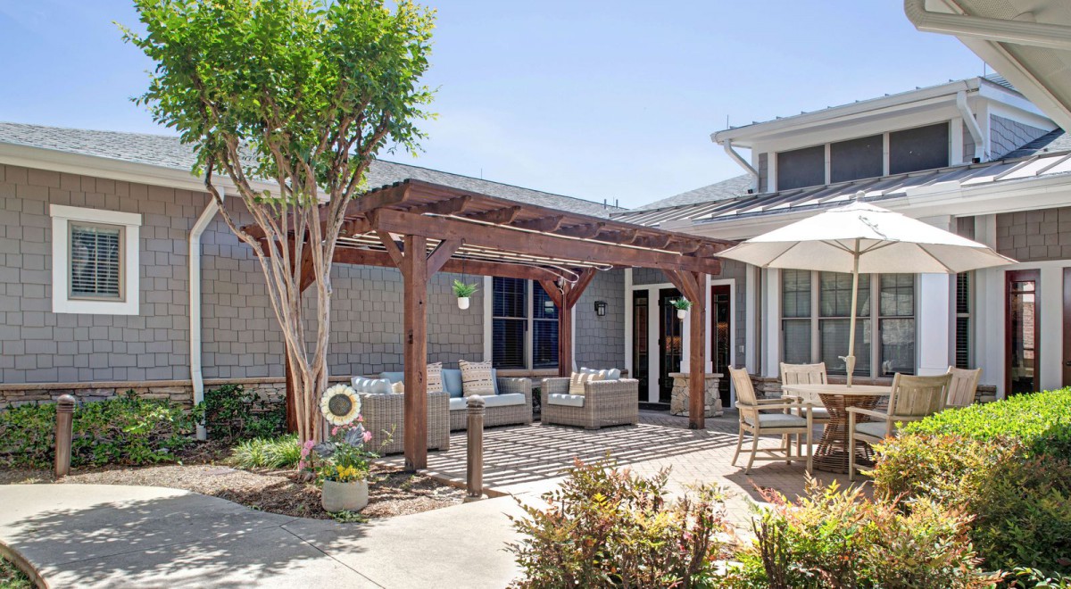 A cozy outdoor patio with a pergola and comfortable seating areas.