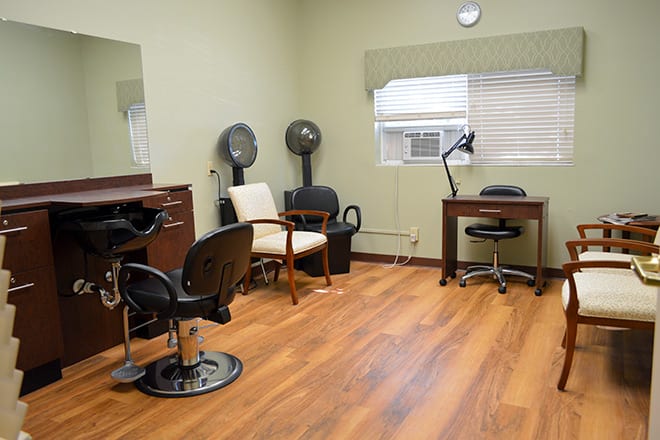 An interior view of a hair salon featuring chairs, mirrors, and hair dryers.