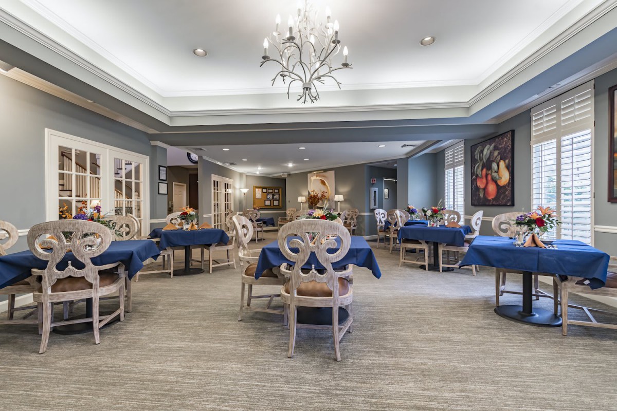 A modern dining area with elegant chandeliers and blue-themed decor.