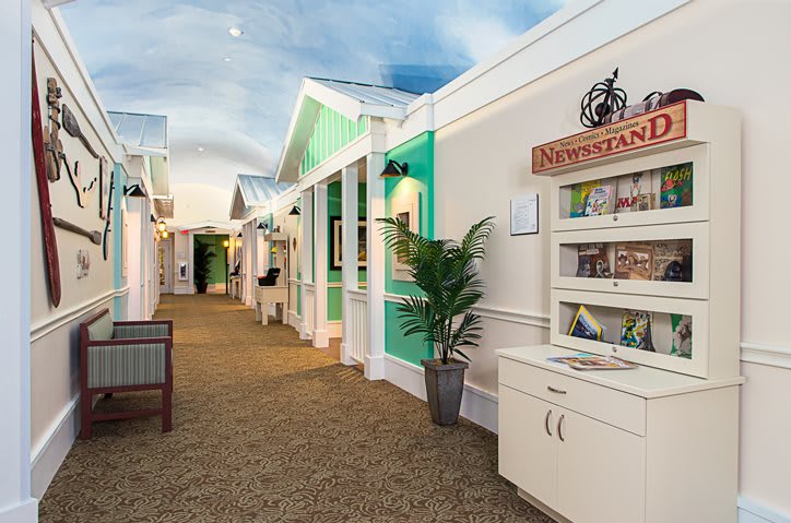 A brightly lit indoor corridor with colorful walls and decorative plants.