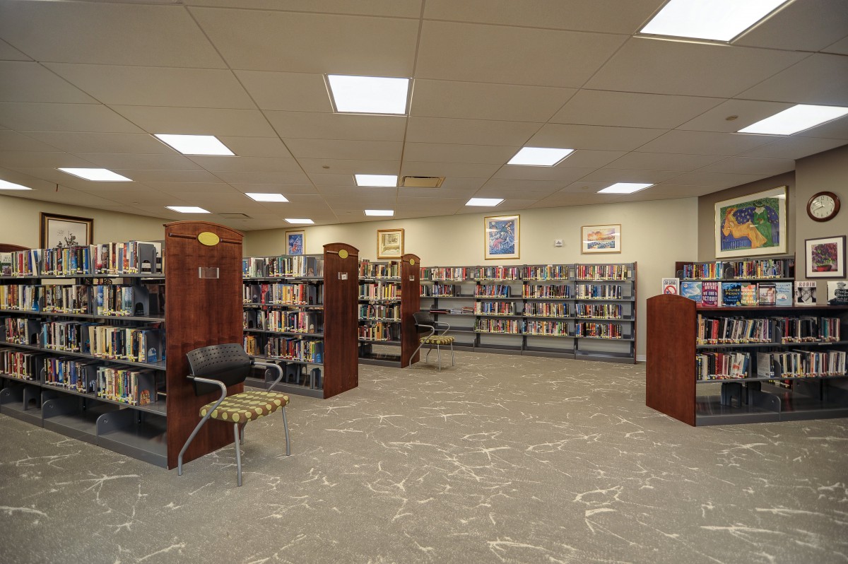 A quiet library interior with rows of bookshelves and seating areas.