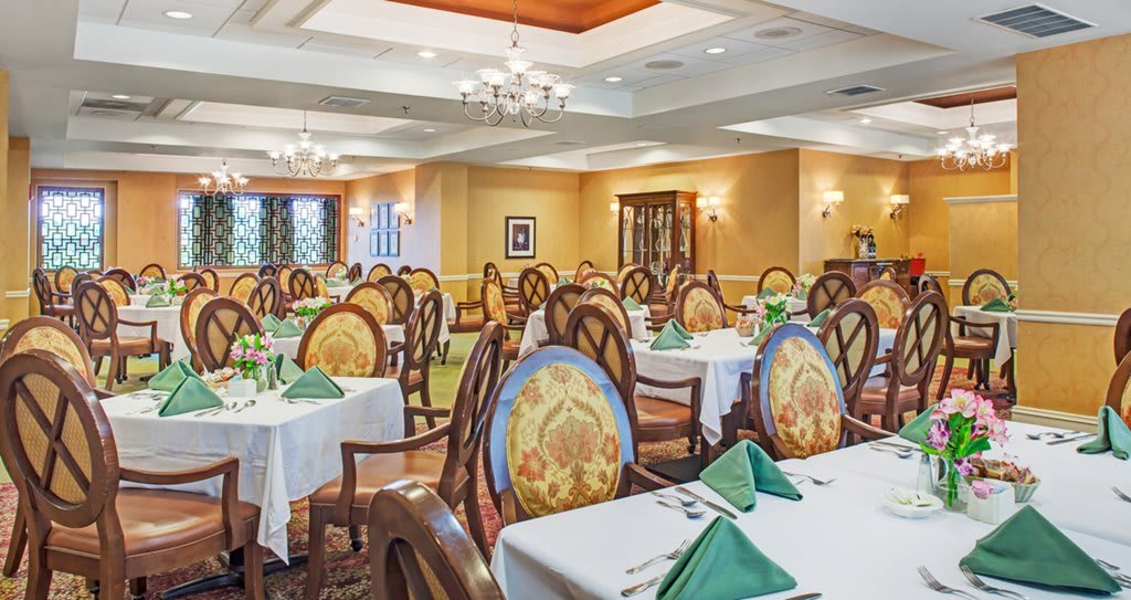 An elegant dining room with neatly arranged tables and chairs, featuring a warm and inviting decor.