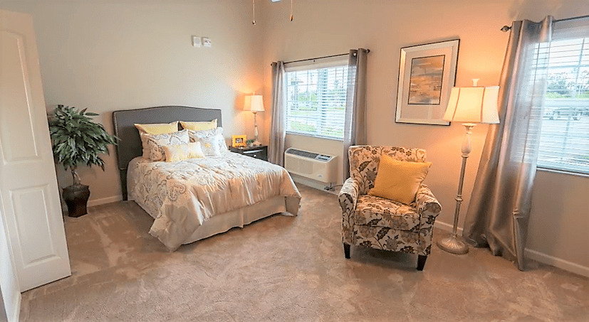 A cozy, well-lit bedroom with a bed, armchair, and decorative elements.