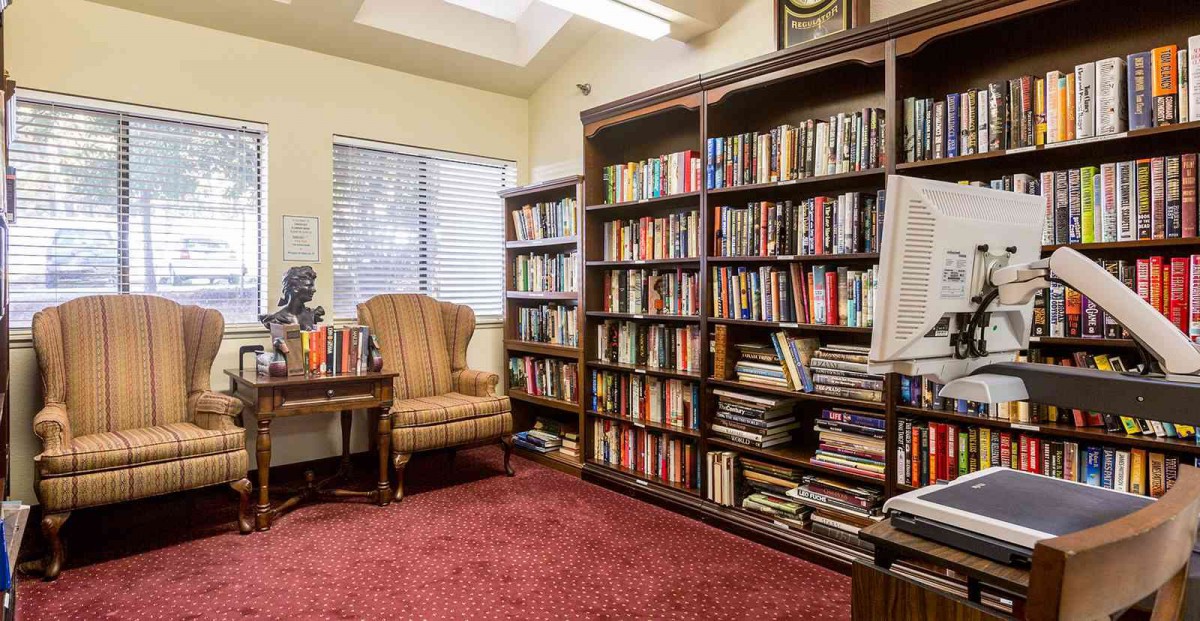 A cozy reading room with bookshelves filled with books and a comfortable armchair.