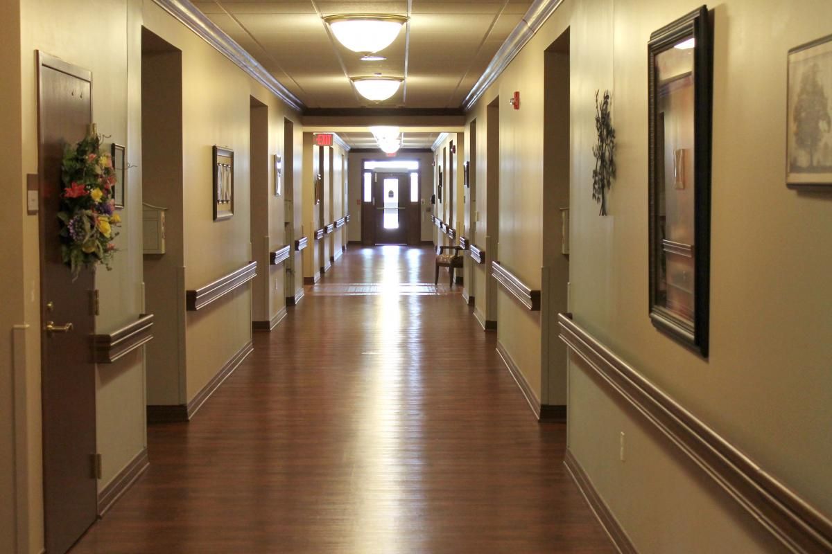 A well-lit hallway with wooden floors and decorated walls.