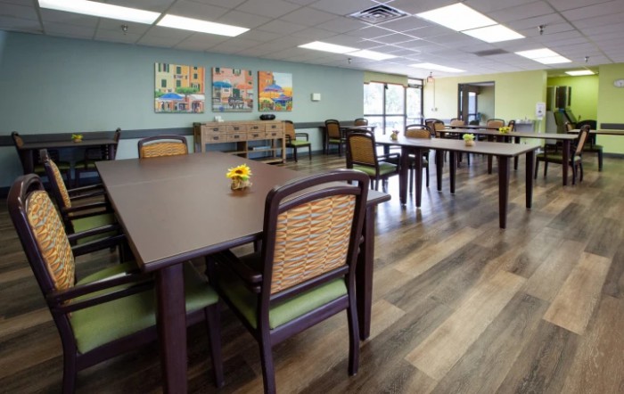 An empty dining area with neatly arranged tables and chairs, featuring a warm and inviting interior.