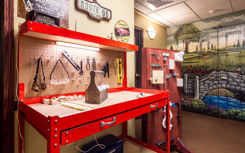 A well-organized workshop features a vibrant red workbench with tools neatly arranged on a pegboard.
