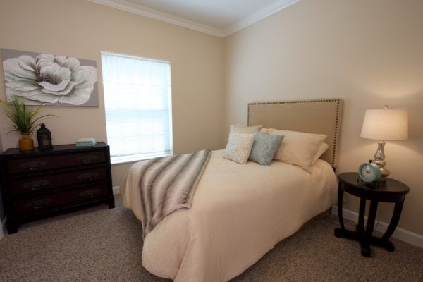 A cozy bedroom with a neatly made bed, soft lighting, and simple decor.