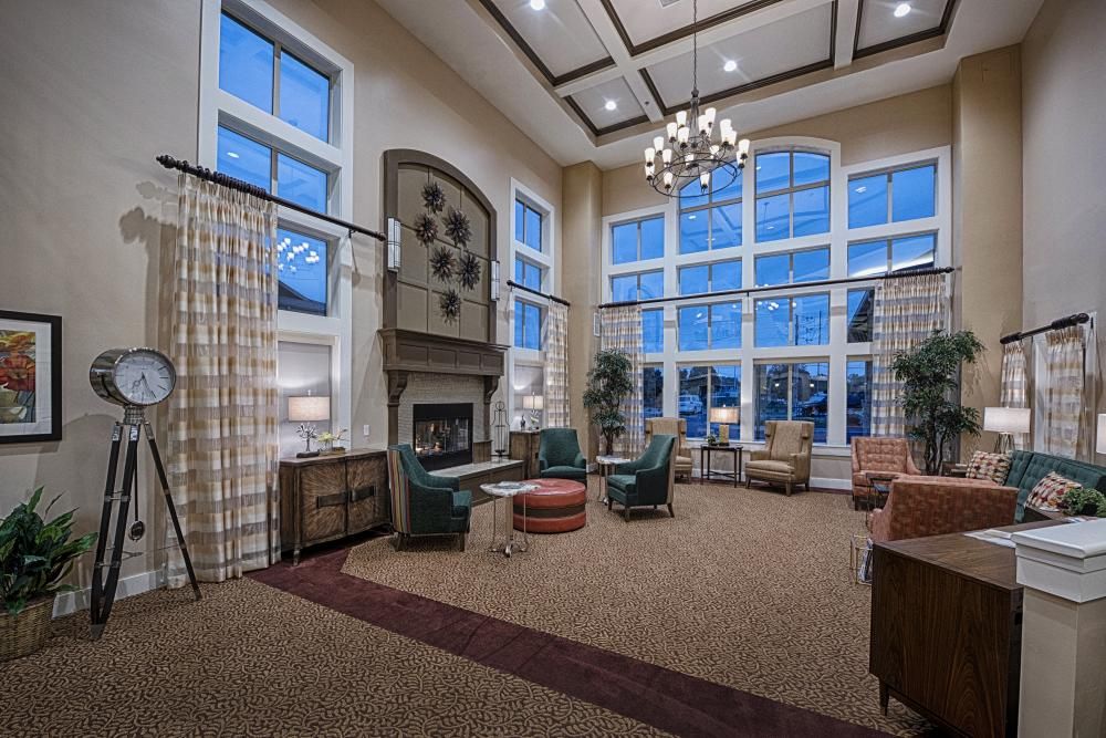 A spacious and cozy living room with large windows, a fireplace, and elegant furniture.