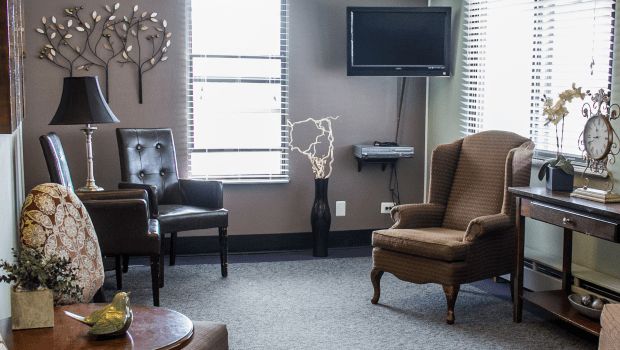 A cozy living room with chairs, a television, and decorative elements.