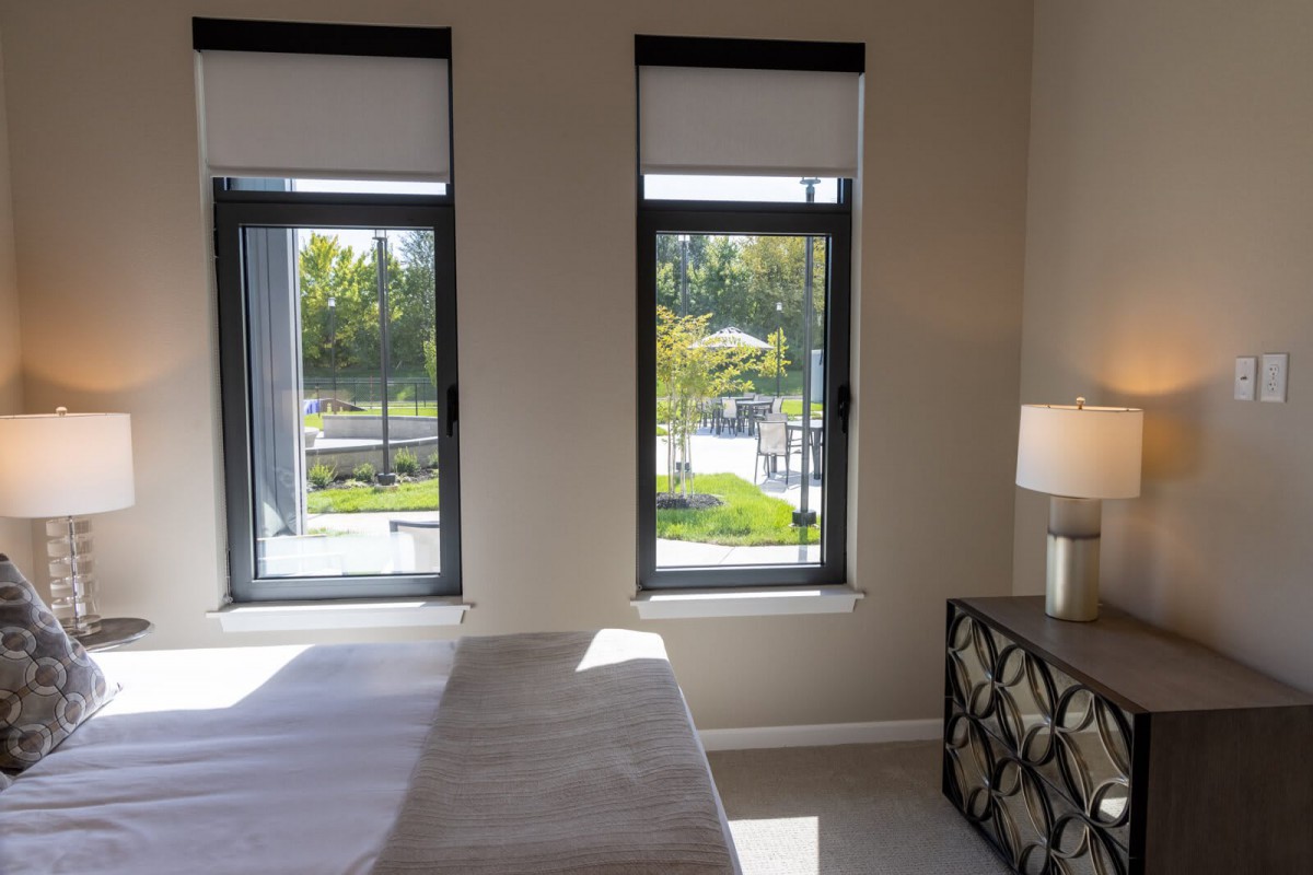 A minimalist bedroom with large windows allowing natural light to fill the space.