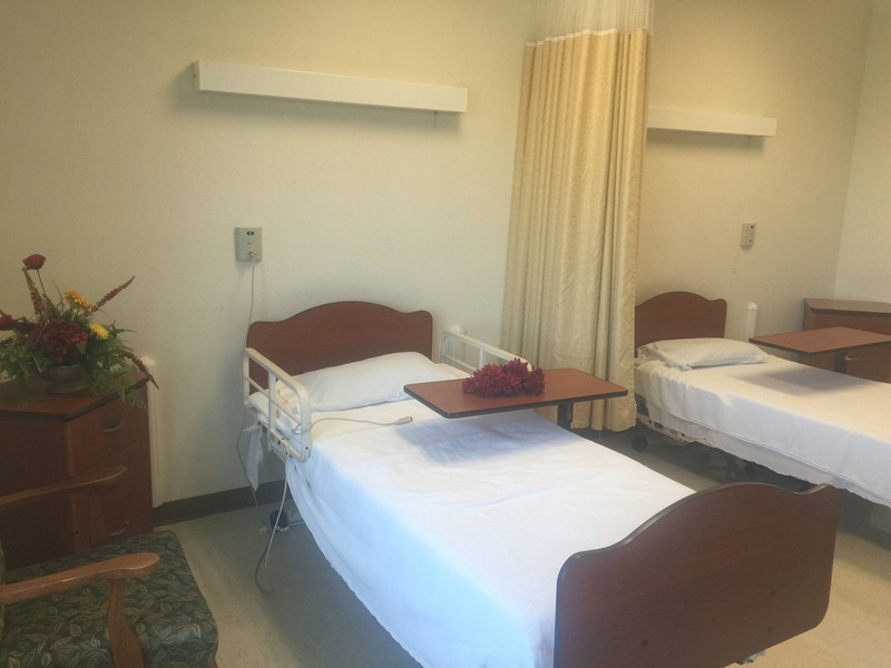 A clean and organized hospital room with a bed and curtain divider.