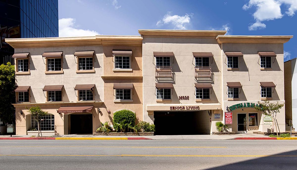 A street view of a commercial building with multiple windows and awnings.