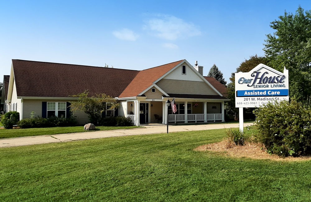 A retirement home with a well-maintained lawn and clear signage.