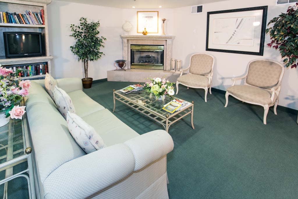 A cozy living room with a fireplace, featuring elegant seating and stylish decor.