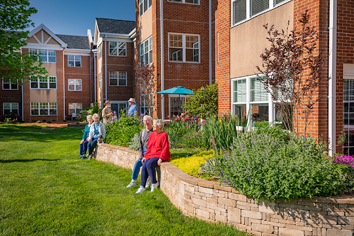 Residents enjoying a sunny day in the garden of their residential community.