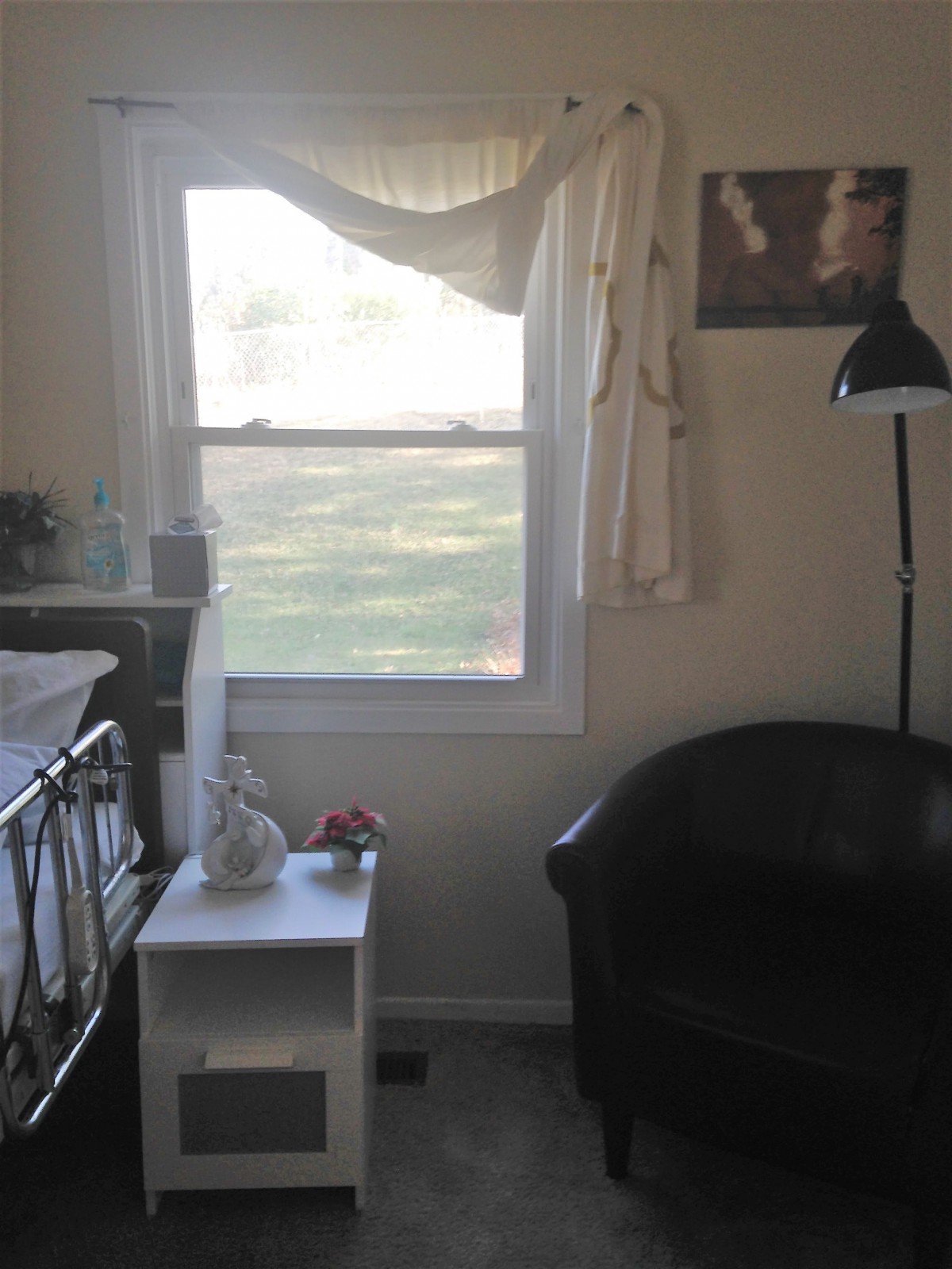 A cozy room with a window, a small table, and a comfortable chair.