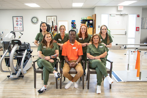 A dedicated team of healthcare professionals posing for a group photo in a rehabilitation center.