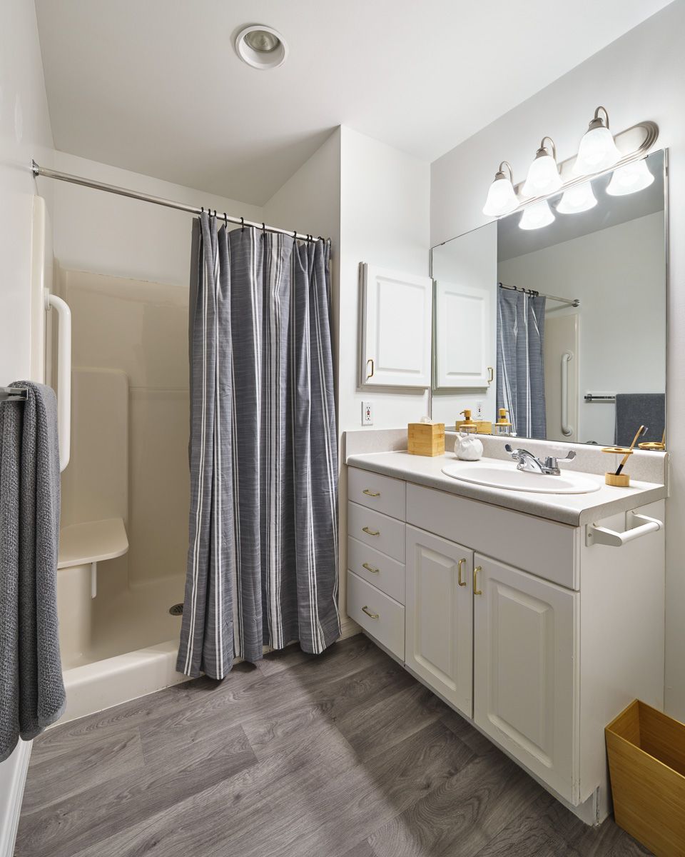 A modern bathroom with a shower, sink, and large mirror.