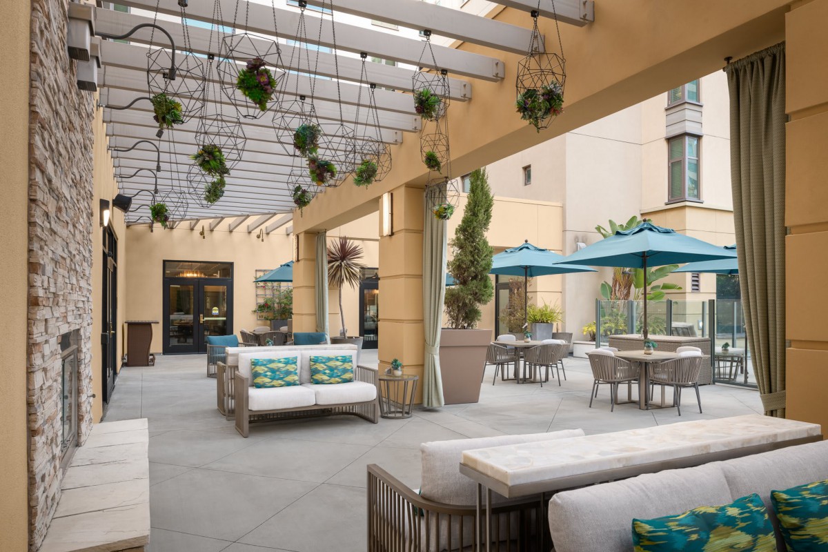A modern outdoor patio with comfortable seating and umbrellas.