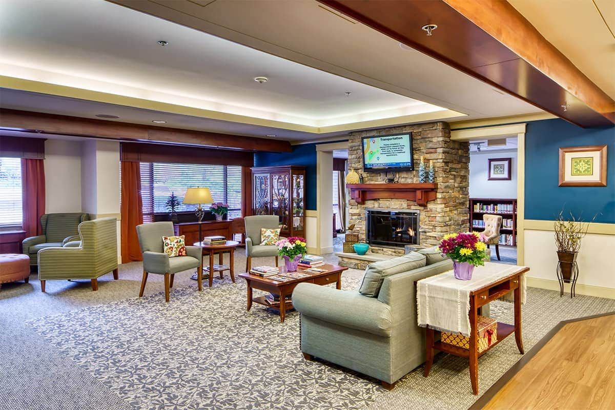 A cozy and elegantly furnished living room with a fireplace, sofas, and a television.