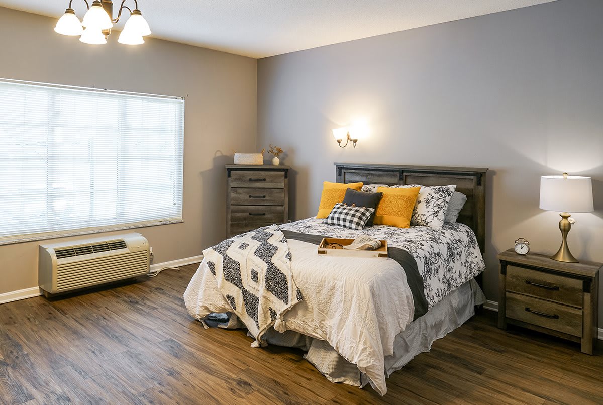 A cozy bedroom with a neatly made bed and bright natural light.