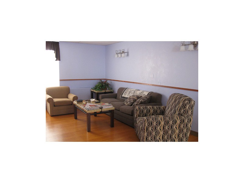 A cozy living room with sofas and armchairs arranged around a central coffee table.
