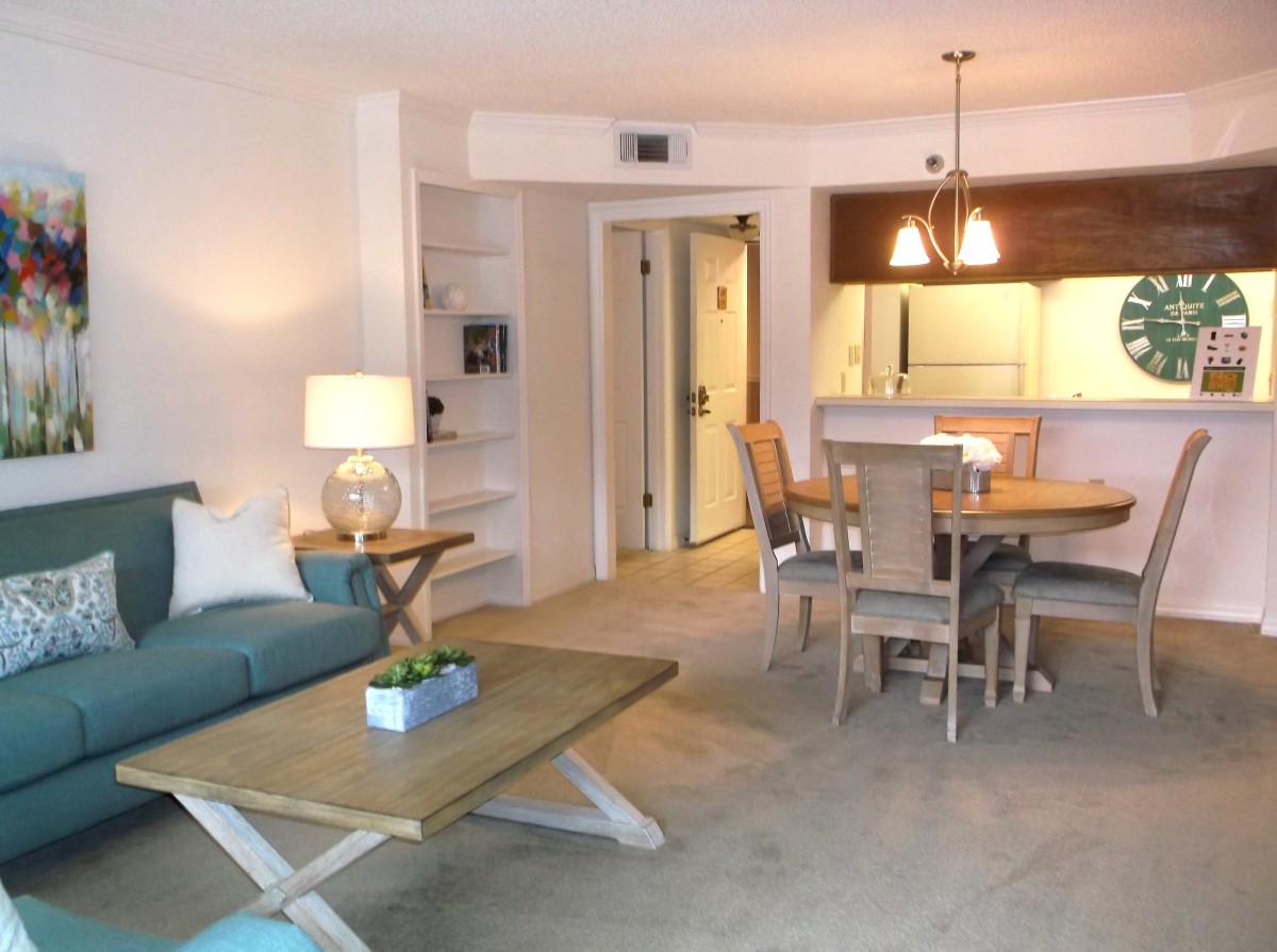 A modern living room and dining area with natural lighting and contemporary furnishings.