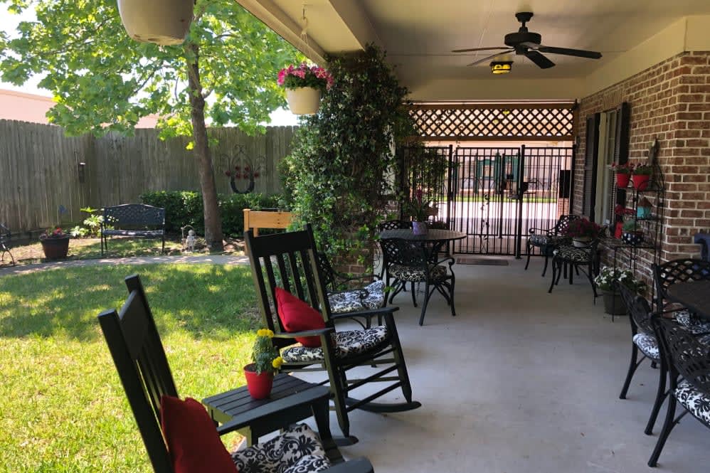 A peaceful patio with rocking chairs and lush greenery.