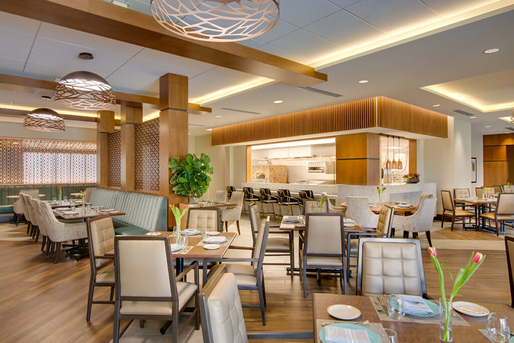 A modern restaurant interior with elegant furniture and table settings.