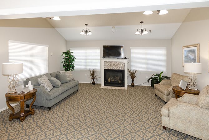 A cozy living room with sofas, armchairs, a fireplace, and a television.