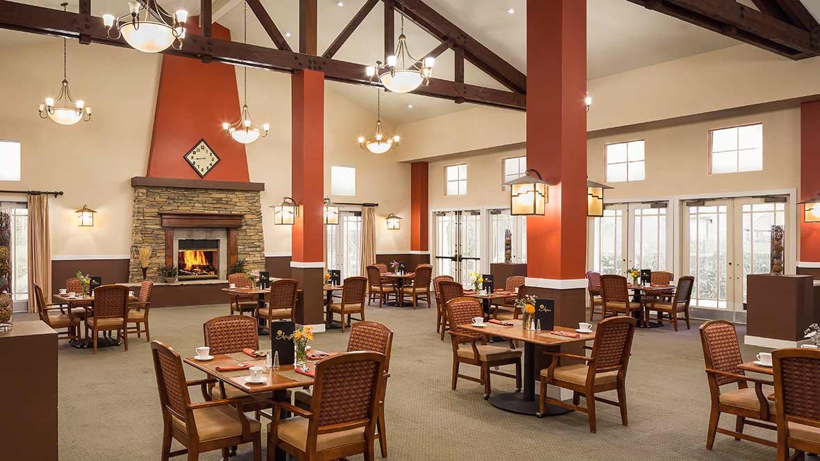 A cozy restaurant interior with a warm fireplace and neatly arranged dining tables.