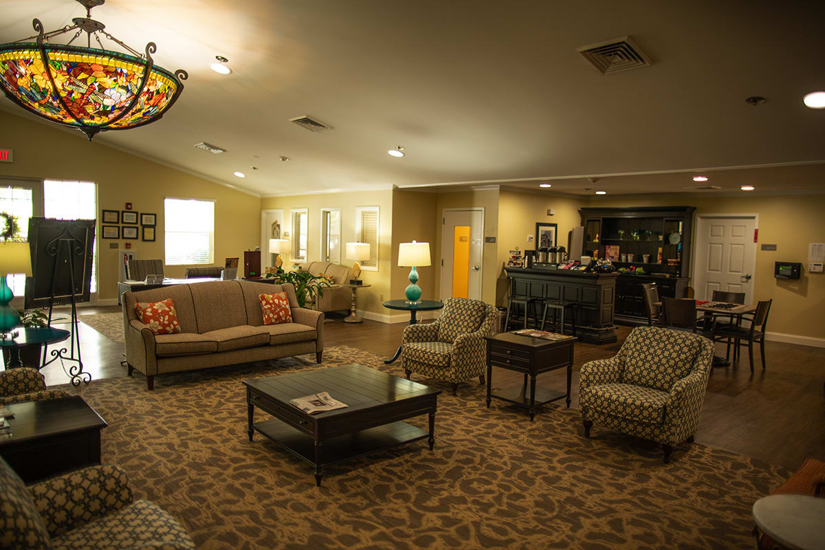 A cozy living room with a sofa, chairs, and a coffee table in a warmly lit space.