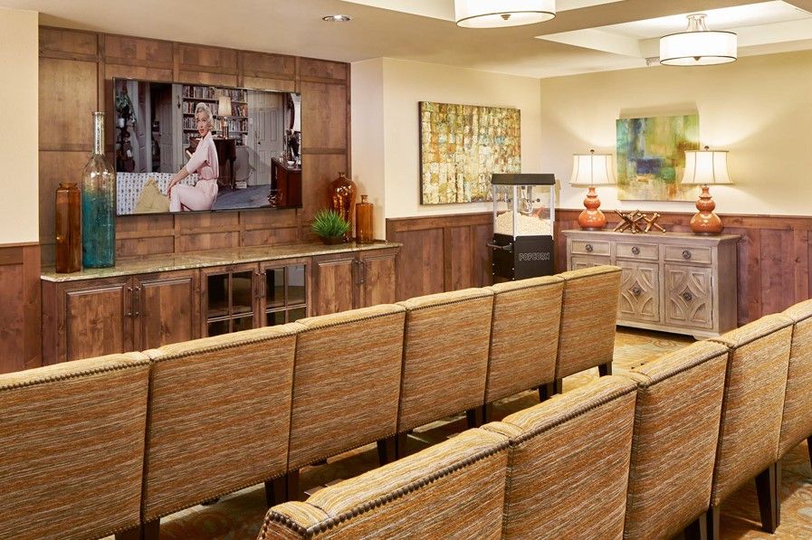 A comfortable waiting room with cushioned seating, a wooden cabinet, and decorative artwork.