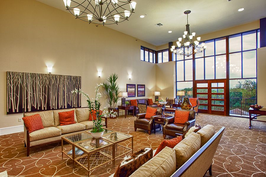 A spacious and elegant lobby with modern furniture and chandeliers.