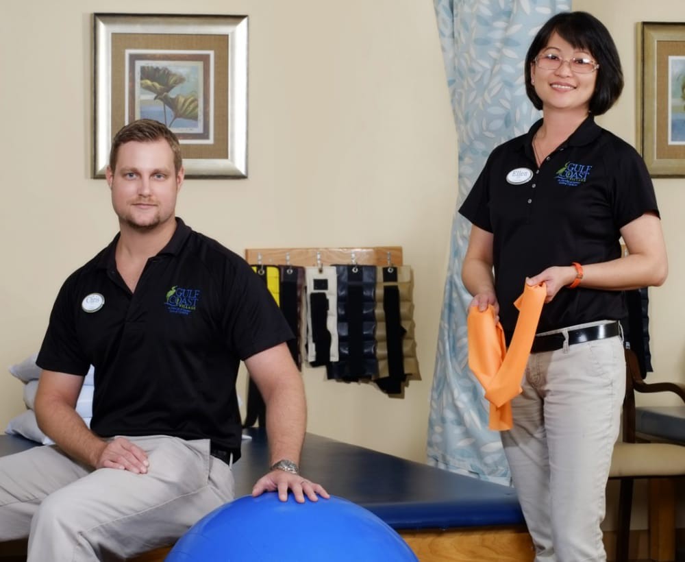Two therapists in a clinic setting with exercise equipment.