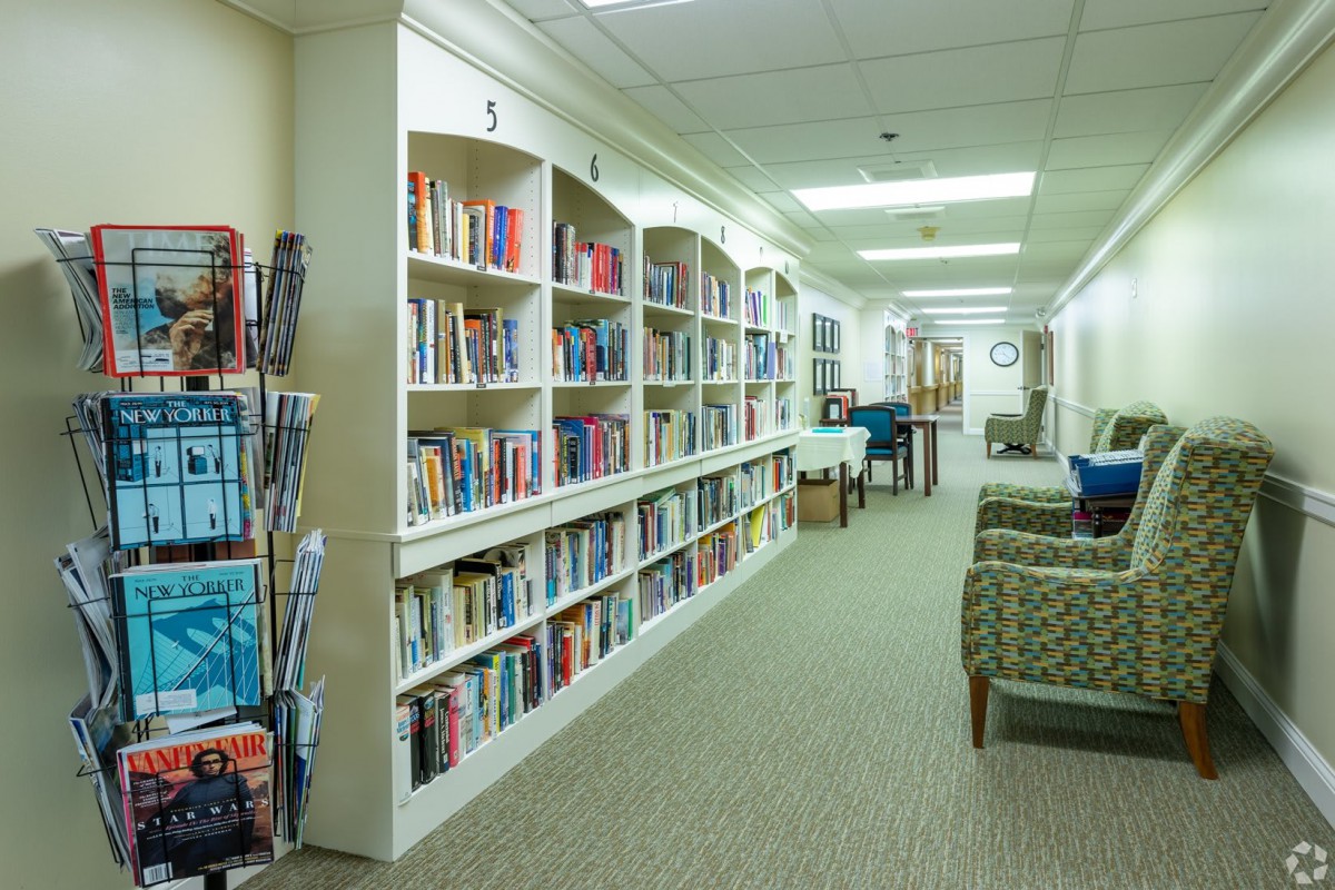 A quiet library hallway with bookshelves filled with books and a comfortable seating area.