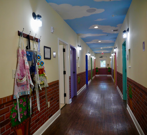 A vibrant hallway featuring colorful doors and a whimsical painted ceiling.