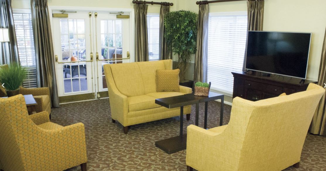 A cozy living room with yellow seating and a coffee table.