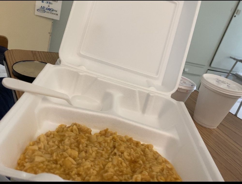 A takeout container filled with rice.