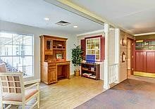 A home office space with wooden furniture and ample natural light.