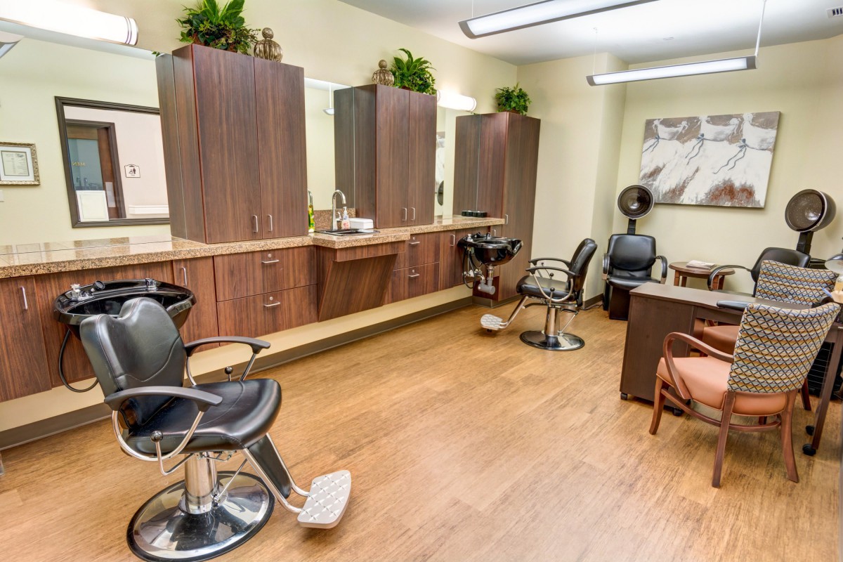 A well-arranged beauty salon with chairs, mirrors, and hair styling equipment.