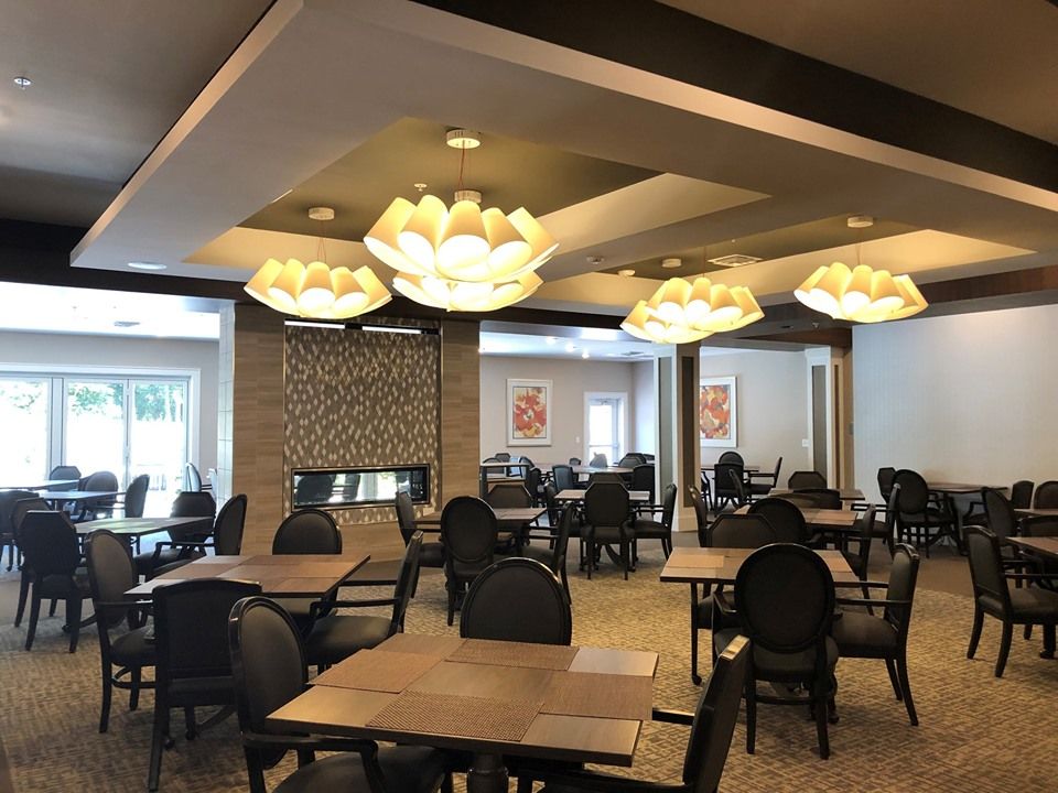 A modern dining room with elegant chandeliers and neatly arranged tables.