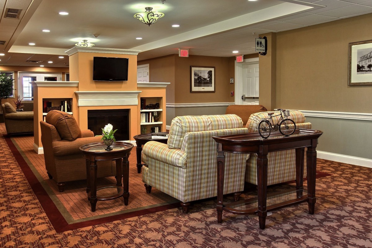 A cozy living room with traditional decor, featuring comfortable seating and a fireplace.